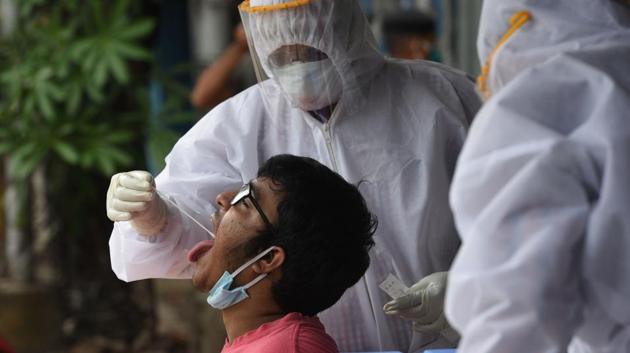 Medics in PPE suits take a swab sample from a person for Covid-19 testing at Muchibazar, ward 13 of Kolkata Municipal Corporation (KMC) in Kolkata, West Bengal on Thursday. (Samir Jana/HT Photo) Medics in PPE suits take a swab sample from a person for Covid-19 testing at Muchibazar, ward 13 of Kolkata Municipal Corporation (KMC) in Kolkata, West Bengal on Thursday. (Samir Jana/HT Photo)