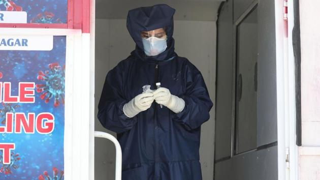 A health worker stands inside a testing van wearing protective gear and gloves in Srinagar on Sunday. (Waseem Andrabi /HT) A health worker stands inside a testing van wearing protective gear and gloves in Srinagar on Sunday. (Waseem Andrabi /HT)