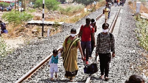 Migrant workers from other states desperate to return to their homes walk through rail tracks towards a train station in Ahmedabad on May 11, 2020. (Photo: AP) Migrant workers from other states desperate to return to their homes walk through rail tracks towards a train station in Ahmedabad on May 11, 2020. (Photo: AP)