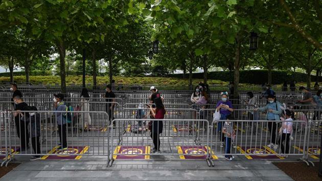 People queue to enter Shanghai Disneyland. To reach the gates of the park, guests had to pass through body temperature checks and show that their health status has been confirmed using a smartphone app for tracking infected persons. Masks were mandatory, despite the muggy 23 degree Celsius (73 degrees Fahrenheit) weather. (Hector Retamal / AFP)