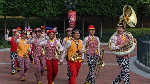 A marching band welcomed visitors to the Shanghai park. Disney is struggling to recoup earnings at its theme park and film businesses pummeled by the virus crisis, while China’s government is grappling with the challenges of incrementally reopening the country. (Hector Retamal / AFP)