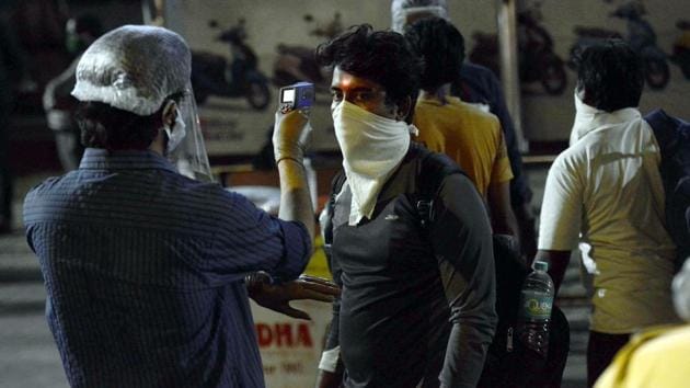 Migrants waiting outside Borivali railway station to board a special train being checked by members of the health department during the nationwide lockdown due to Covid, in Mumbai on Monday. (ANI file photo)