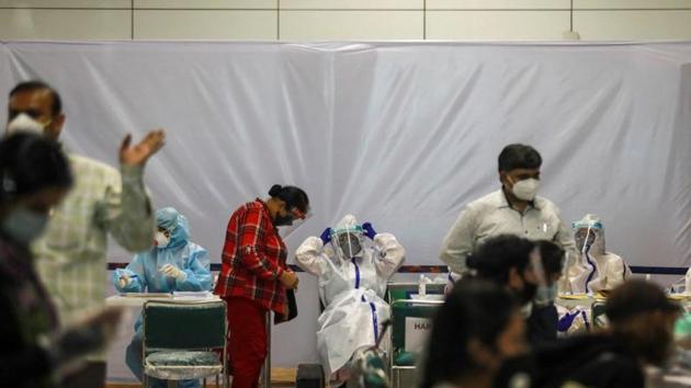 Indian nationals, who were stranded in Singapore due to the coronavirus disease (Covid-19) outbreak, are seen along with medics wearing personal protective equipment (PPE) at the airport, upon their arrival in New Delhi, India. (REUTERS) Indian nationals, who were stranded in Singapore due to the coronavirus disease (Covid-19) outbreak, are seen along with medics wearing personal protective equipment (PPE) at the airport, upon their arrival in New Delhi, India. (REUTERS)