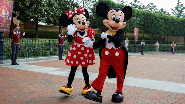 Disney characters Mickey Mouse and Minnie Mouse are seen entertaining the crowd. Live theatre shows, areas where children would come into close contact, such as water play spots, and parades have been suspended during the initial reopening to avoid raising infection risks. (Aly Song / REUTERS)