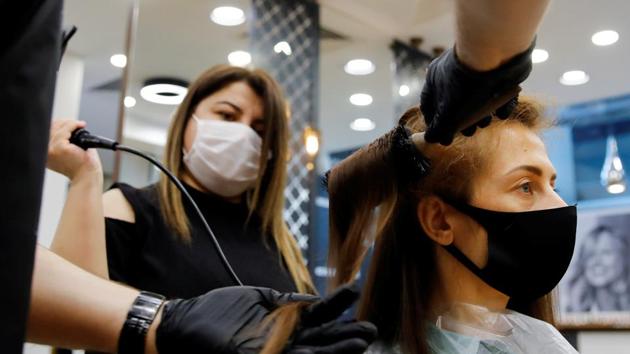 A hairdresser gives hair treatment to his customer Elena Kuznetsova, wearing a protective mask, on the first day of the reopening of his hair salon which was closed since March 21 amid the spread of the coronavirus disease (COVID-19), in Istanbul, Turkey.(REUTERS) A hairdresser gives hair treatment to his customer Elena Kuznetsova, wearing a protective mask, on the first day of the reopening of his hair salon which was closed since March 21 amid the spread of the coronavirus disease (COVID-19), in Istanbul, Turkey.(REUTERS)