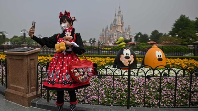 A woman wearing a face mask takes a selfie during her visit to Disneyland. Shanghai Disneyland was the first of the entertainment giant’s parks to close on January 25 as the coronavirus began to spread from the Chinese city of Wuhan, 520 miles (840 kilometers) west of the country’s business capital. (Hector Retamal / AFP)