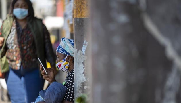 A woman wearing face masks to protect against coronavirus, holds her child whilst using a mobile phone on the sidewalk in downtown Johannesburg, South Africa, Monday, May 11, 2020. (AP photo) A woman wearing face masks to protect against coronavirus, holds her child whilst using a mobile phone on the sidewalk in downtown Johannesburg, South Africa, Monday, May 11, 2020. (AP photo)