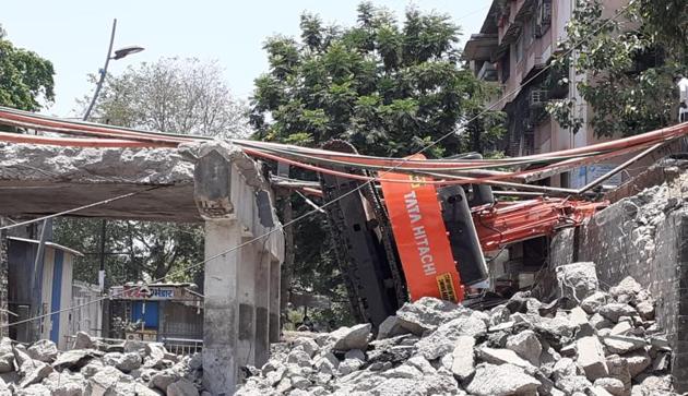 The excavator lost control and fell on the road below the under-construction Dombivli rail overbridge.(HT photo)