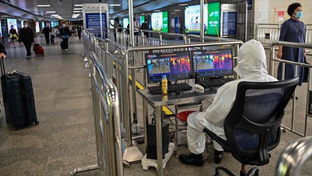 A worker in protective gear looks at a screen showing body temperatures of passengers at Hankou railway station. Wu Zunyou, chief epidemiologist at the Chinese Center for Disease Control and Prevention, told state broadcaster CCTV it was “not necessary” for every person in Wuhan to be tested. (Hector RETAMAL / AFP)