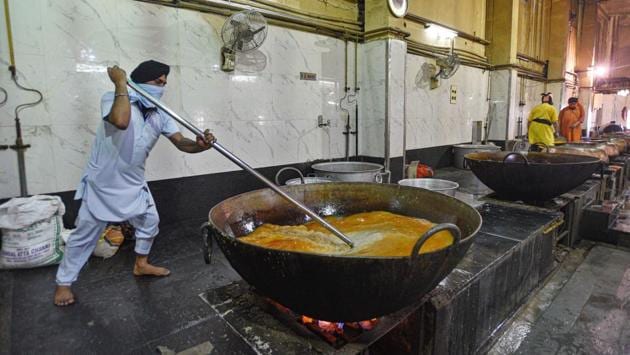 A ‘sevak’ in the kitchen at the Gurudwara Bangla Sahib in New Delhi stirs food in a large utensil as food is prepared for the day’s distribution. The ongoing nationwide lockdown against the coronavirus has left thousands scrambling for meals in the capital. Community kitchens such as this one have been working tirelessly to their aid. (Biplov Bhuyan / HT Photo) A ‘sevak’ in the kitchen at the Gurudwara Bangla Sahib in New Delhi stirs food in a large utensil as food is prepared for the day’s distribution. The ongoing nationwide lockdown against the coronavirus has left thousands scrambling for meals in the capital. Community kitchens such as this one have been working tirelessly to their aid. (Biplov Bhuyan / HT Photo)