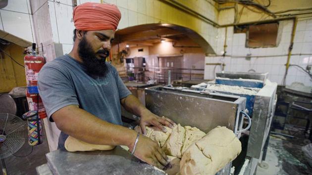 Dough is kneaded in a machine that helps speed up the process of preparing the large number of meals served by the kitchen. The Gurudwara Bangla Sahib has been feeding as many as 80,000 people daily since the lockdown began on March 25, Rajinder Singh, an assistant manager at the gurudwara told HT. (Biplov Bhuyan / HT Photo) Dough is kneaded in a machine that helps speed up the process of preparing the large number of meals served by the kitchen. The Gurudwara Bangla Sahib has been feeding as many as 80,000 people daily since the lockdown began on March 25, Rajinder Singh, an assistant manager at the gurudwara told HT. (Biplov Bhuyan / HT Photo)