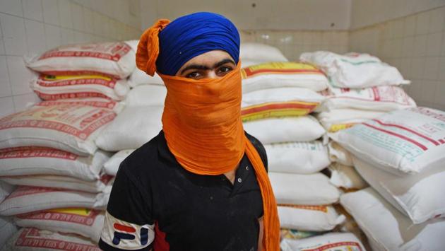 Manpreet Singh, 19, a full-time staffer in the kitchen at the Gurudwara Bangla Sahib seen against sacks of flour. Around 50 people are currently engaged in the kitchen. The rations and funds for keeping the operation going come from donors. (Biplov Bhuyan / HT Photo) Manpreet Singh, 19, a full-time staffer in the kitchen at the Gurudwara Bangla Sahib seen against sacks of flour. Around 50 people are currently engaged in the kitchen. The rations and funds for keeping the operation going come from donors. (Biplov Bhuyan / HT Photo)