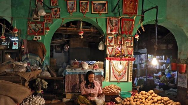 A vendor waits for customers at his shop inside a vegetable market in Kolkata, India.(REUTERS)