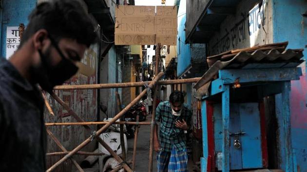 Men walk past a makeshift barricade that was set up to stop people from entering a lane, during a nationwide lockdown in India to slow the spread of COVID-19, in Dharavi, one of Asia's largest slums, during the coronavirus disease outbreak, in Mumbai. (REUTERS) Men walk past a makeshift barricade that was set up to stop people from entering a lane, during a nationwide lockdown in India to slow the spread of COVID-19, in Dharavi, one of Asia's largest slums, during the coronavirus disease outbreak, in Mumbai. (REUTERS)