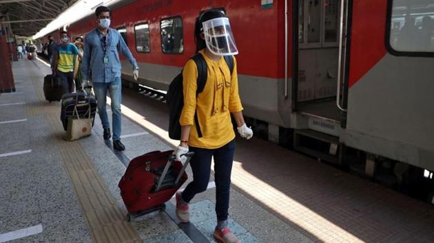 People with their luggage walk to board a train that will take them to New Delhi, at the Howrah Junction railway station in Kolkata. Travel comes with additional guidelines. Passengers are encouraged to carry their own food, water and travel light. (Rupak de Chowdhuri / REUTERS) 