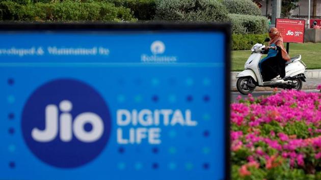 A woman rides her scooter past advertisements of Reliance Industries' Jio telecoms unit, in Ahmedabad, India. (REUTERS) A woman rides her scooter past advertisements of Reliance Industries' Jio telecoms unit, in Ahmedabad, India. (REUTERS)