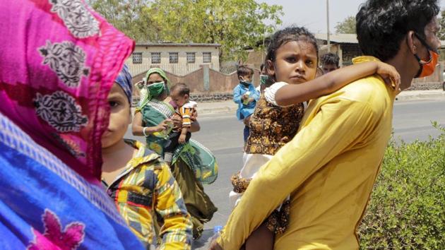 A migrant workers family desperate to reach their home in neighboring Madhya Pradesh state walk through a highway anticipating road transport from the outskirts of the city in Mumbai, India. (AP) A migrant workers family desperate to reach their home in neighboring Madhya Pradesh state walk through a highway anticipating road transport from the outskirts of the city in Mumbai, India. (AP)