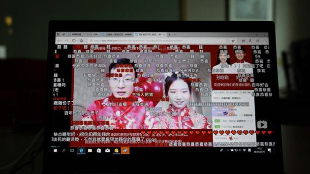 A livestream recording of the wedding of Liu Wenchao (L) and Sun Hanxiao is seen on a laptop screen in Beijing. Coronavirus lockdowns and travel restrictions have forced couples around the world to delay their wedding plans or adapt to these unusual times by holding ceremonies via online video platforms. But in China, where livestreaming is extremely popular, young couples are allowing people to not only watch their big day online, but also send them cash as gifts. (Greg Baker / AFP)