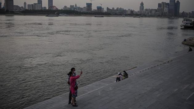 A couple wearing face masks take a selfie by the Yangtze River in Wuhan. The city of around 630,000 people has been put under a partial lockdown since Saturday. (Hector RETAMAL / AFP)