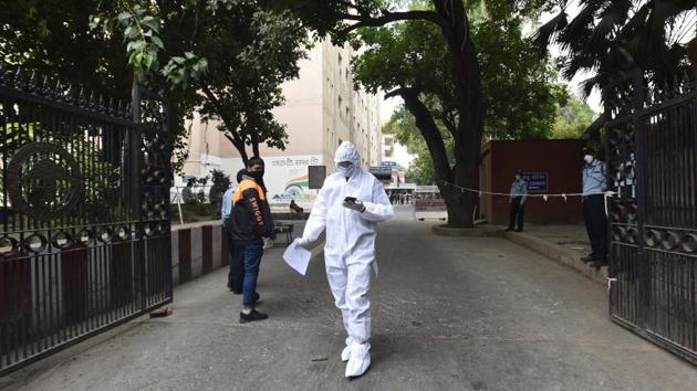 A man in PPE coverals leaves carrying a COVID-19 test report at RML hospital during lockdown in New Delhi, India. (Sonu Mehta/HT PHOTO) A man in PPE coverals leaves carrying a COVID-19 test report at RML hospital during lockdown in New Delhi, India. (Sonu Mehta/HT PHOTO)