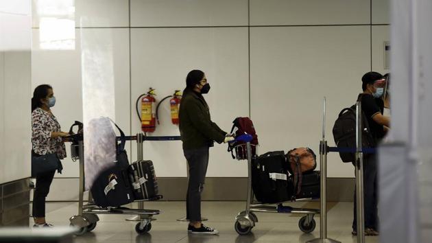 Indian nationals, who were stranded in Singapore amid Covid-19 pandemic, wait for screening after they were brought by a special Air India flight at IGI Airport in New Delhi on Friday. (PTI File Photo)