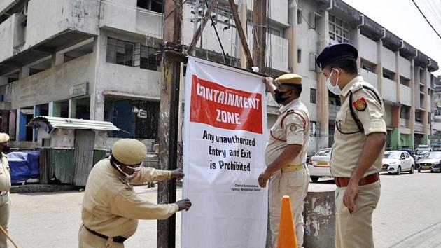 Police personnel hanging a banner in an area that has been declared a containment zone during the coronavirus pandemic in Guwahati.(ANI PHOTO.)