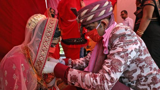 An Indian couple performs marriage rituals wearing protective masks in New Delhi. As the lockdown prevails, couples do not have much choice except postponing their wedding or opting for a simple one. (ANI)