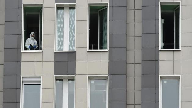 A medic wearing protective gear looks out from a window of the Saint George hospital after a fire broke out in the medical facility in Saint Petersburg on May 12. Despite the steady rise in new cases, Russia’s reported mortality rate is significantly lower compared to other European countries hit hard by the pandemic, with 96 new deaths and a total of 2,212 dead from the coronavirus as of Wednesday, reported AFP. (Olga Maltseva / AFP)