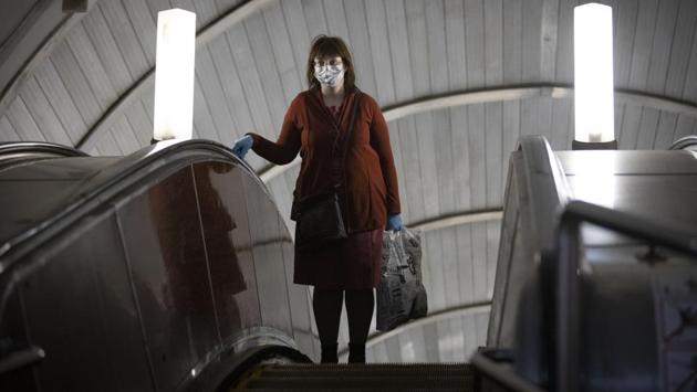 A woman wearing face mask and gloves seen on the subway escalator in Moscow. Beginning Tuesday, wearing face masks and latex gloves were made mandatory for people using Moscow’s public transport, reported AP. (Alexander Zemlianichenko / AP)