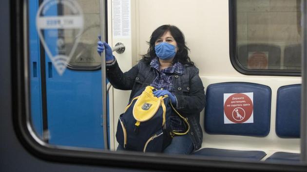 A woman seen wearing a face mask and gloves rides a carriage in the subway in Moscow on May 12. Moscow’s Mayor Sergei Sobyanin has also extended the lockdown until the end of May. (Alexander Zemlianichenko / AP)