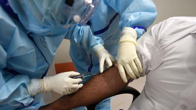 Medical professionals collect blood sample from a suspected COVID-19 patient, in Institute of Liver and Biliary Science (ILBS) hospital, New Delhi.(Biplov Bhuyan/HT PHOTO)