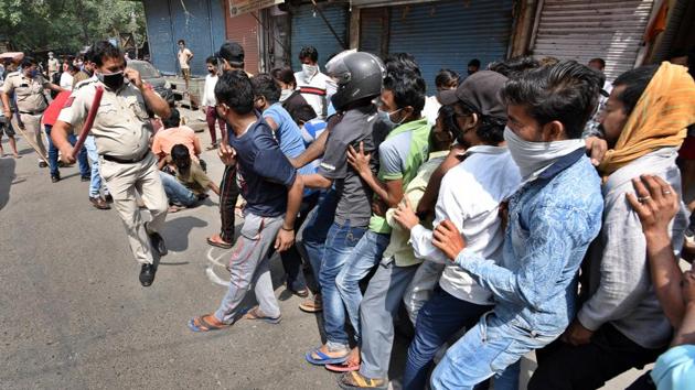 Police personnel wield lathis in an attempt to ensure social distance in a large crowd queued outside a liquor shop in Jheel Chowk after relaxations allowed their opening, in New Delhi. (Ajay Aggarwal /HT PHOTO) Police personnel wield lathis in an attempt to ensure social distance in a large crowd queued outside a liquor shop in Jheel Chowk after relaxations allowed their opening, in New Delhi. (Ajay Aggarwal /HT PHOTO)