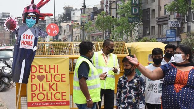 People walk past a cutout with precautionary messages against the coronavirus, put up by the police in Paharganj, New Delhi. (Sonu Mehta/HT PHOTO) People walk past a cutout with precautionary messages against the coronavirus, put up by the police in Paharganj, New Delhi. (Sonu Mehta/HT PHOTO)