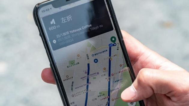 Miyake holds a mobile app showing the direction to a cafe as the Japanese fencer prepares to collect an order. “When I get orders in the hilly Akasaka, Roppongi (downtown) district, it becomes good training,” Miyake told AFP. (Philip Fong / AFP)