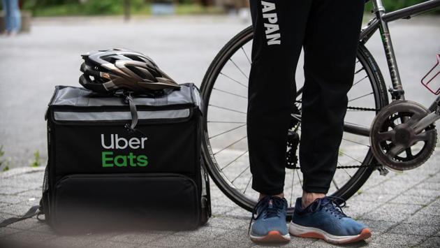 Miyake stands next to his food delivery bag and a cycling helmet during an interview. The International Olympics Committee has set the new date for the Olympics on July 23, 2021. But with no vaccine available for the coronavirus that has killed nearly 300,000 worldwide, even that hangs in the balance. (Philip Fong / AFP)