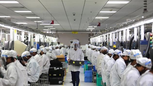 Workers wearing face shields work at an assembly line of mobile phones after some restrictions were lifted during an extended nationwide lockdown to slow the spread of the coronavirus disease (COVID-19) in Noida.(REUTERS) Workers wearing face shields work at an assembly line of mobile phones after some restrictions were lifted during an extended nationwide lockdown to slow the spread of the coronavirus disease (COVID-19) in Noida.(REUTERS)