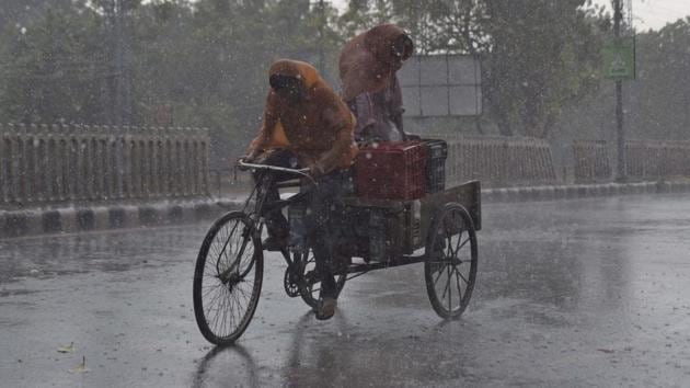 Commuters rushing home amid heavy rain. (HT Photo) Commuters rushing home amid heavy rain. (HT Photo)