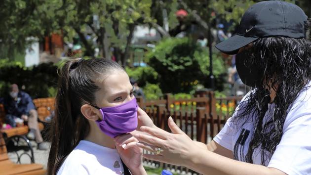 A mother wearing a face mask for protection against the coronavirus, adjusts her daughter's mask in Kugulu public garden, in Ankara, Turkey. (AP) A mother wearing a face mask for protection against the coronavirus, adjusts her daughter's mask in Kugulu public garden, in Ankara, Turkey. (AP)