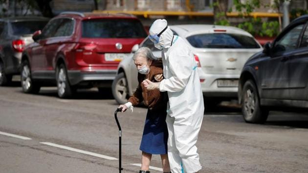A medical specialist, wearing a protective suit amid the coronavirus disease Covid-19 outbreak, assists an elderly woman to cross a road in Moscow on May 14. (Reuters Photo) A medical specialist, wearing a protective suit amid the coronavirus disease Covid-19 outbreak, assists an elderly woman to cross a road in Moscow on May 14. (Reuters Photo)