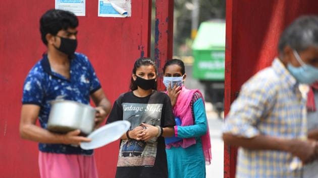 People wait in a queue to collect food at a food distribution in the Delhi government school, at Lodhi road, in New Delhi.(Raj K Raj/HT PHOTO)