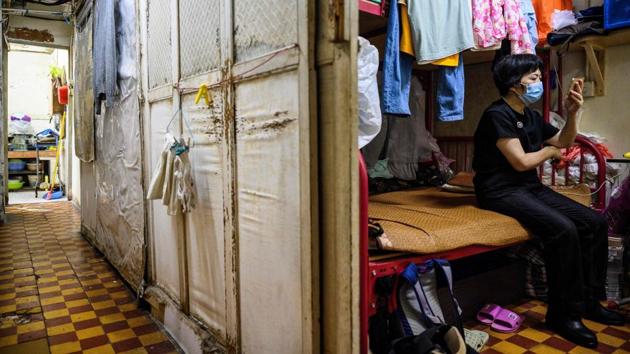 Wong seen on her mobile phone in the walk-up flat. She dreams of having an apartment for just herself and her son, who works in construction business. “But that would cost HK$7,000-8,000 per month, about the same as what I earn each month,” she said. (Anthony Wallace / AFP) Wong seen on her mobile phone in the walk-up flat. She dreams of having an apartment for just herself and her son, who works in construction business. “But that would cost HK$7,000-8,000 per month, about the same as what I earn each month,” she said. (Anthony Wallace / AFP)