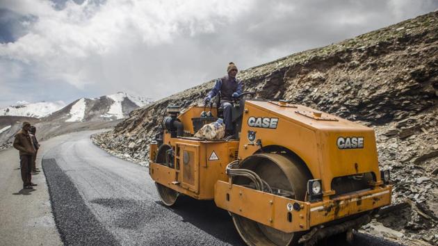 A Border Roads Organisation (BRO) worker drives a steamroller while repairing a road surface with tarmac on a section of the Leh Manali highway in Ladakh region.(Photographer: Prashanth Vishwana)