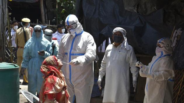 A medical worker in PPE overalls takes a swab sample for Covid-19 testing at the Qaiserbagh Vegetable Market which is a coronavirus hotspot, in Lucknow, Uttar Pradesh.(Dheeraj Dhawan / Hindustan Times)