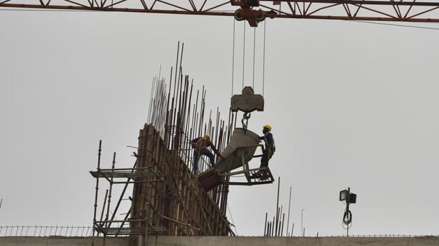 Labourer at work in a building near Gaur Chowk ,during the nationwide lockdown, in Noida.(Virendra Singh Gosain/HT PHOTO)