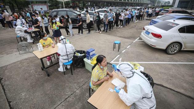 Medical workers take swab samples to be tested for the COVID-19. The mass testing is part of China’s efforts to fortify against a potential “second wave” after a cluster of cases emerged in a residential community over the last weekend. (STR / AFP / China OUT )