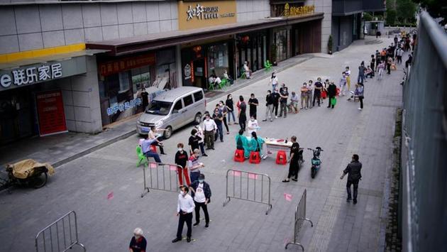 Residents wearing face masks queue for nucleic acid testings in Wuhan. The priority for the tests are residents who have not been tested before, people living in residential compounds that had previous cases of the virus, as well as old or densely populated estates. (Aly Song / REUTERS)