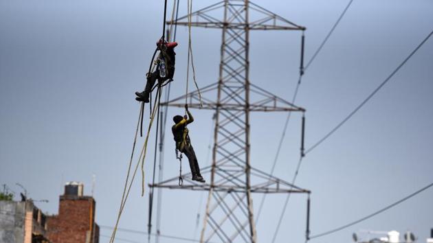 A man repairs an electric power cable at Ganesh Nagar, in New Delhi.(Raj K Raj/HT PHOTO) A man repairs an electric power cable at Ganesh Nagar, in New Delhi.(Raj K Raj/HT PHOTO)