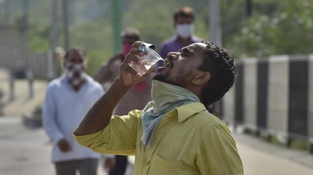 A migrant worker drinks water at National Highway as he walks towards his native state, at Ghazipur Border, in New Delhi.(Burhaan Kinu/HT PHOTO) A migrant worker drinks water at National Highway as he walks towards his native state, at Ghazipur Border, in New Delhi.(Burhaan Kinu/HT PHOTO)