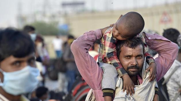A migrant carrying his child on shoulders, New Delhi, Friday, May 15, 2020. (Ajay Aggarwal /HT PHOTO) A migrant carrying his child on shoulders, New Delhi, Friday, May 15, 2020. (Ajay Aggarwal /HT PHOTO)