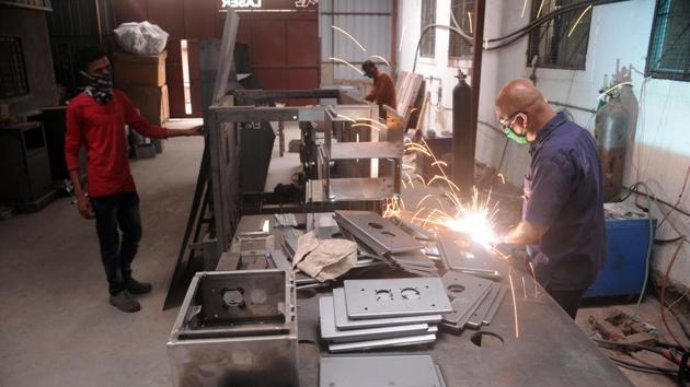 Small scale firms located at Narhe, Ambegaon industrial area began operations on Friday. Workers are seen wearing masks and maintaining social distance at their workshops.(HT photo)